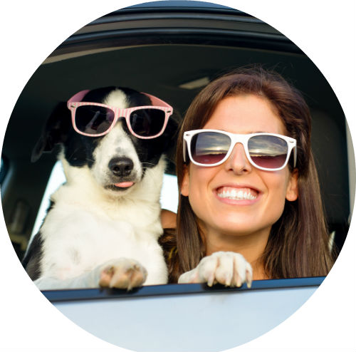 girl and dog in car window