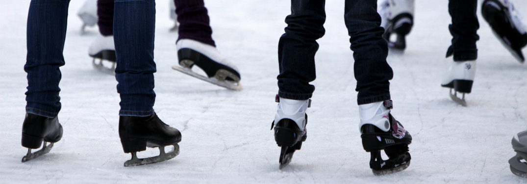 Close-up-of-peoples-skates-while-they-ice-skate