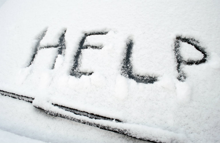 Snow-covered-windshield-wiper-with-help-written-in-snow