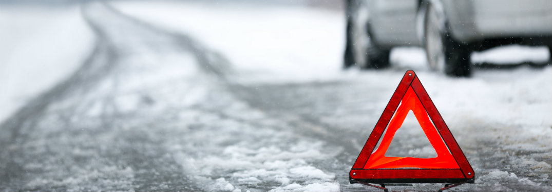 Warning-triangle-on-snow-covered-slushy-road