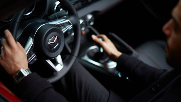 Close-up-of-driver-and-steering-wheel-inside-2018-Mazda-MX-5-Miata-RF
