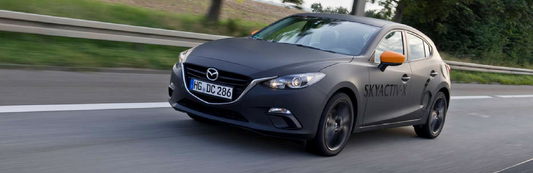 2019 Mazda3 driving down a road.