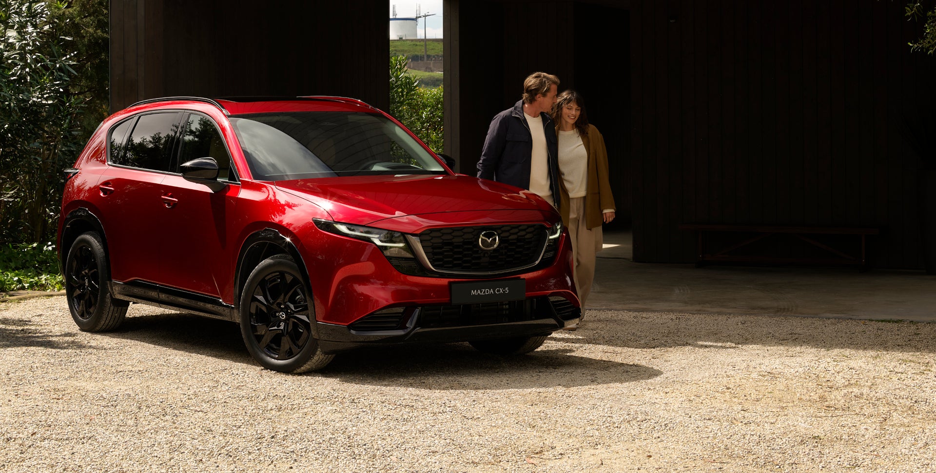 A couple and their 2026 Mazda CX-5 parked outside their home