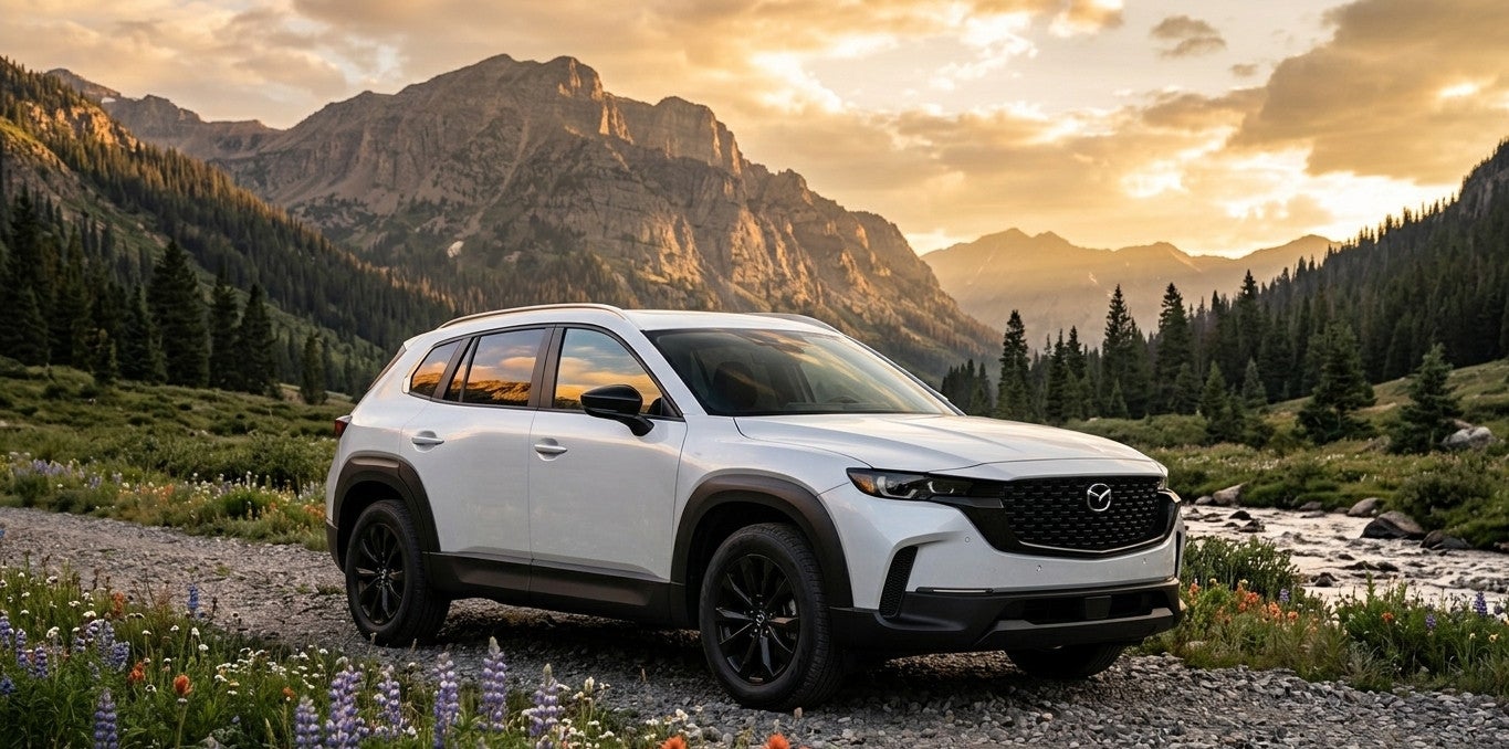 A white 2026 Mazda CX-50 hybrid in a mountainous scene