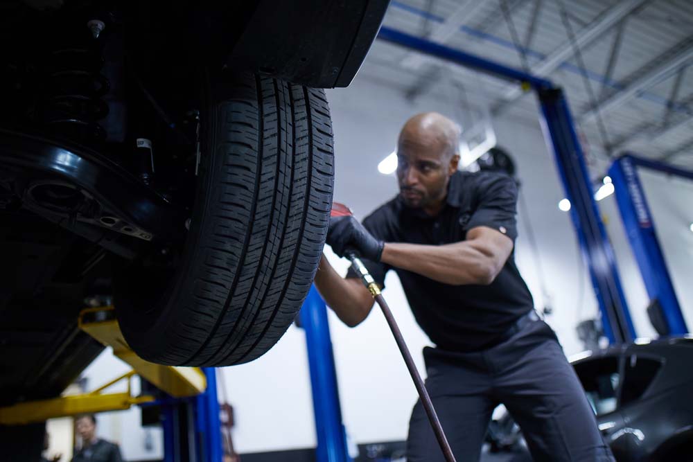 A Mazda technician working on a Mazda vehicles tires