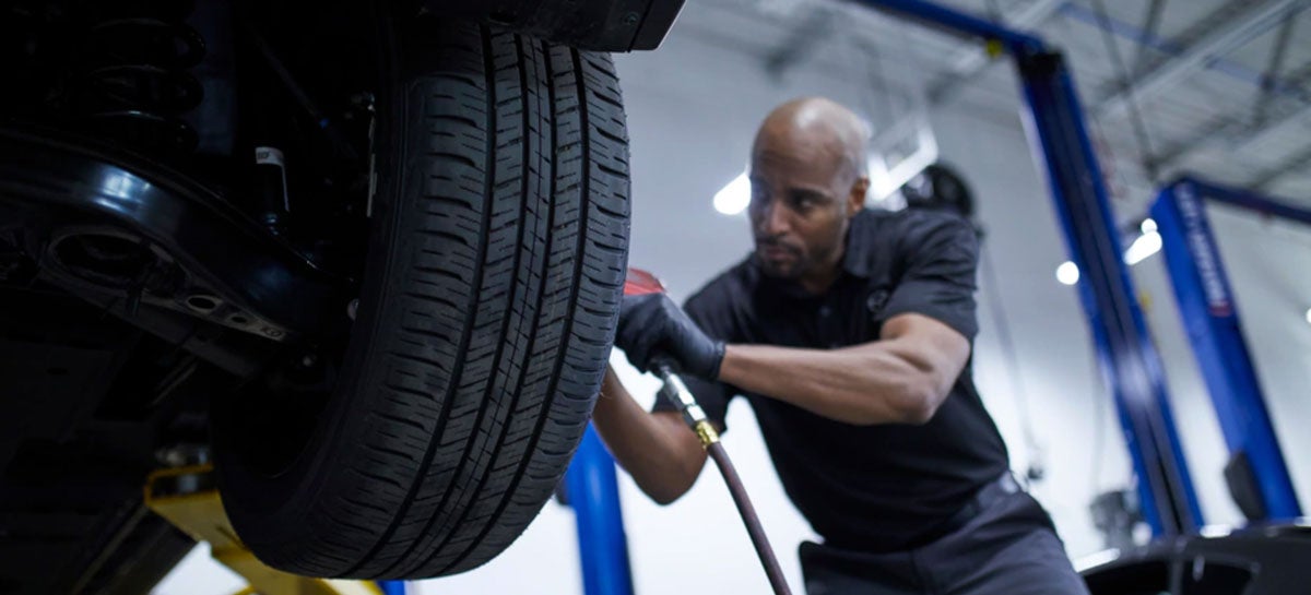 Mazda service technician performing wheel alignment in Portsmouth, NH