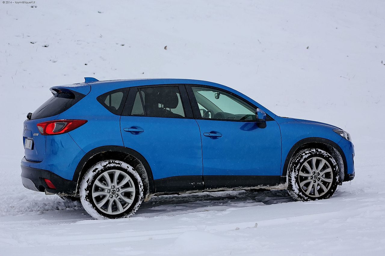 A Mazda CX-5 in a wintery scene surround by snow