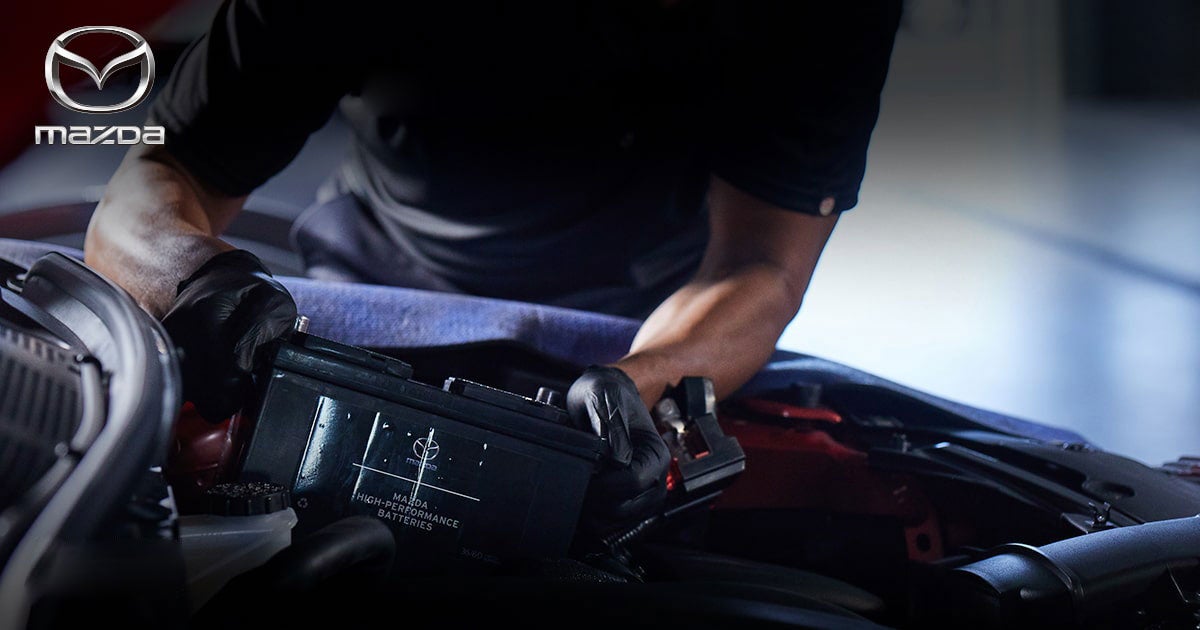 Mechanic repairing a car battery damaged from cold weather.