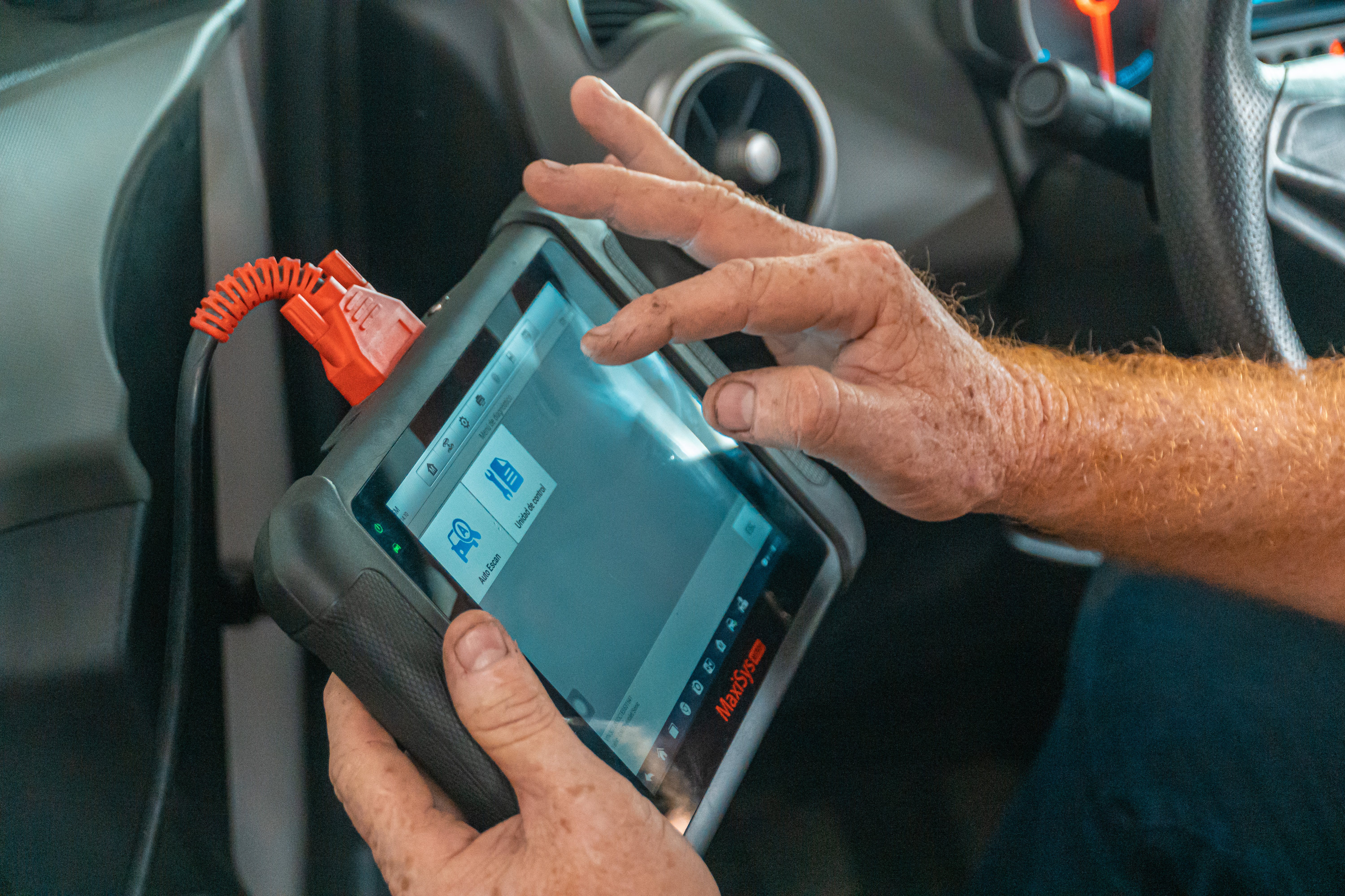 A technician uses a computer diagnostic tool on a vehicle
